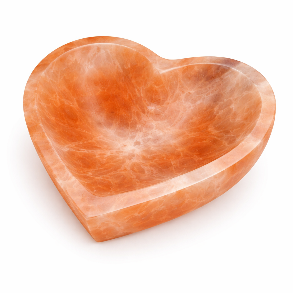 Orange heart selenite charging bowl in a close product view on white