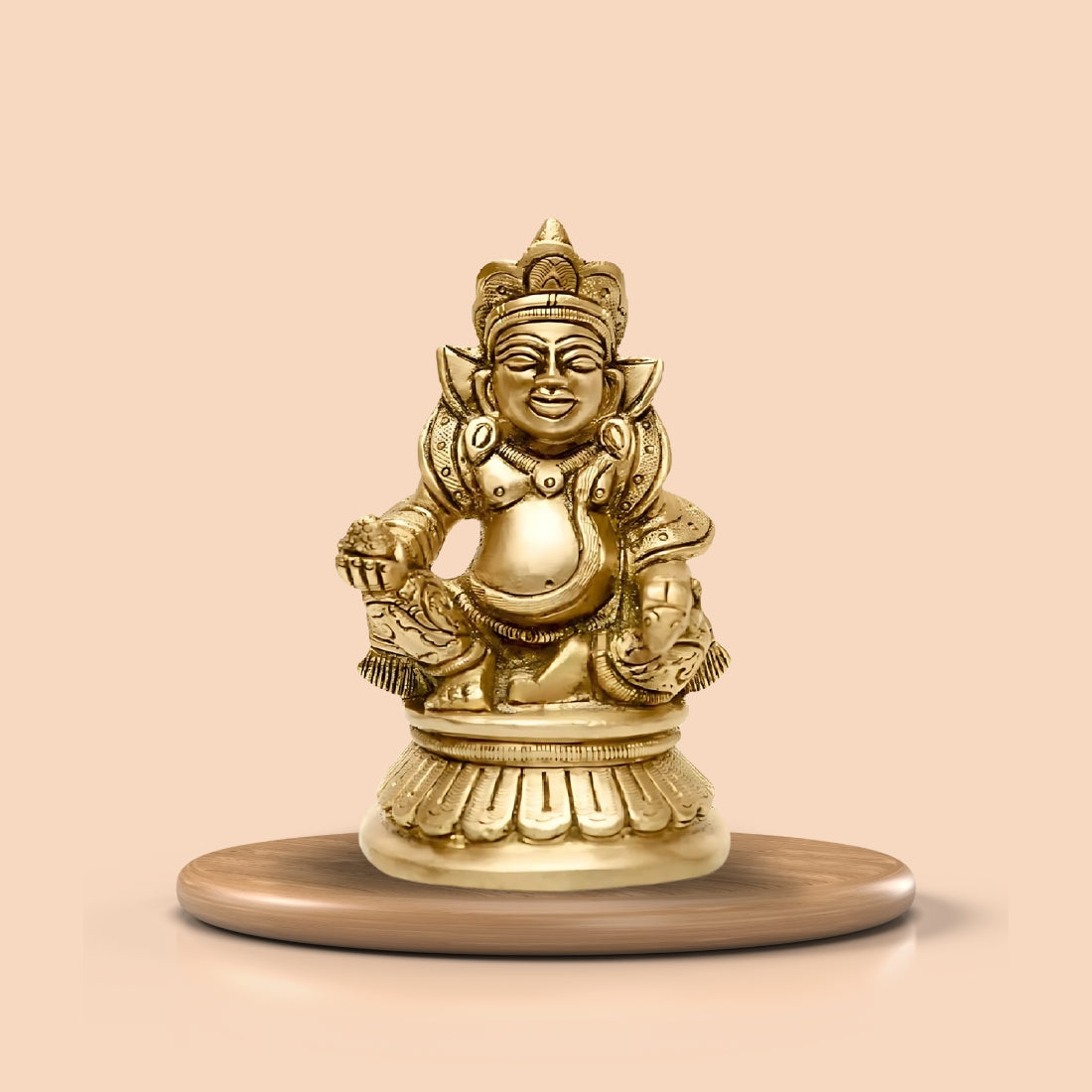 Brass Kuber Ji idol displayed on a round pedestal against a peach background