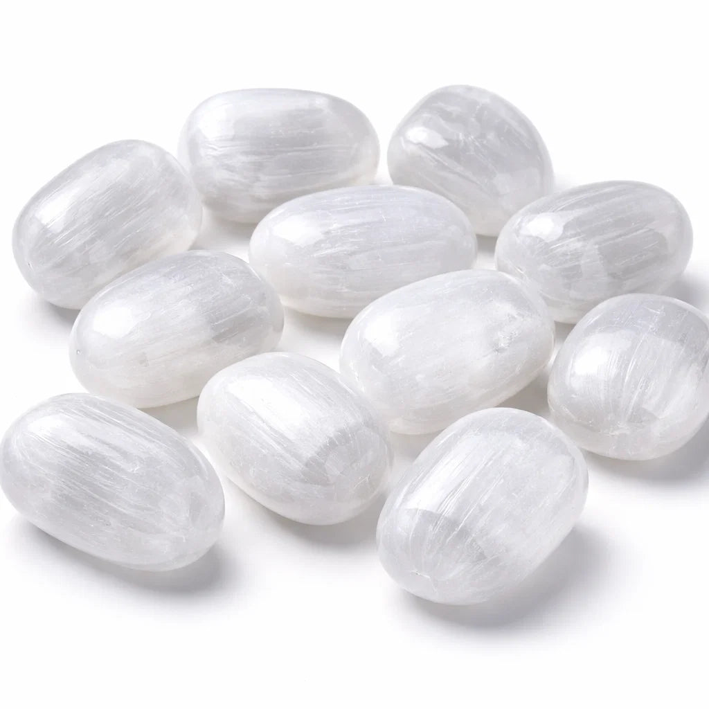 Oval polished selenite stones grouped on a clean white background