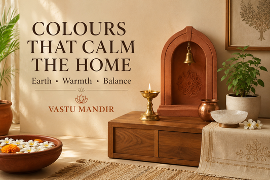 Earthy Vastu colours in a modern Indian home with beige wall, terracotta accent, brass diya, copper detail, crystal bowl, and green plant.