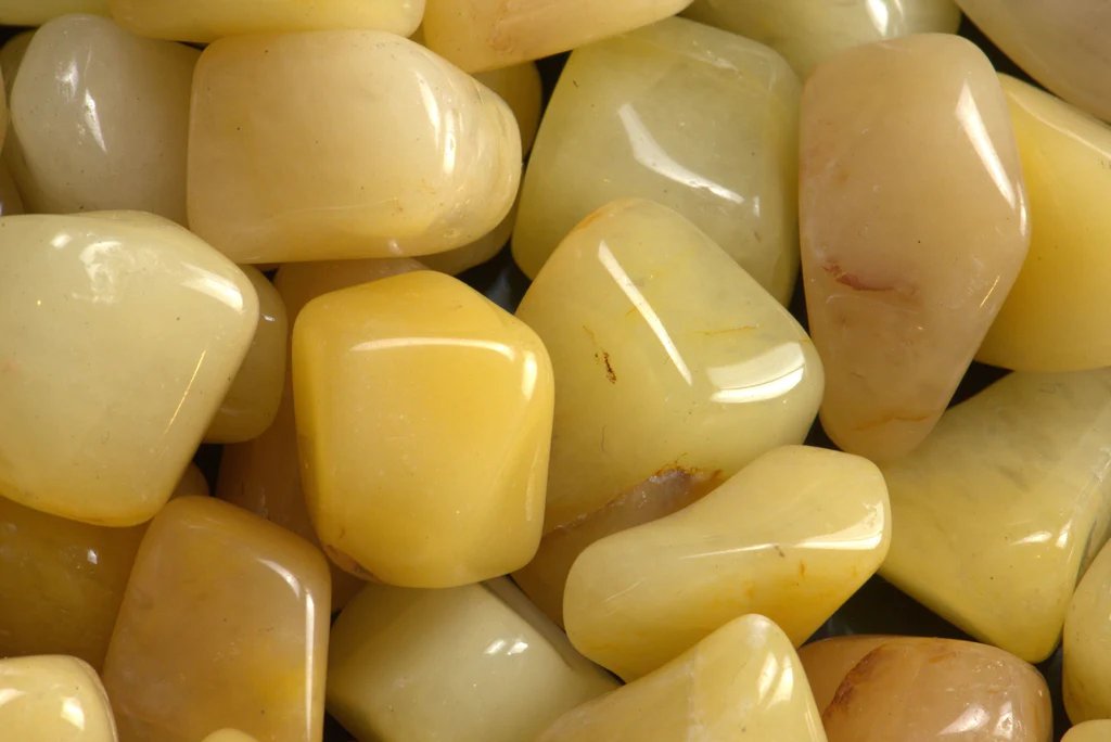 Macro close-up of pale yellow jade stones showing cloudy natural markings