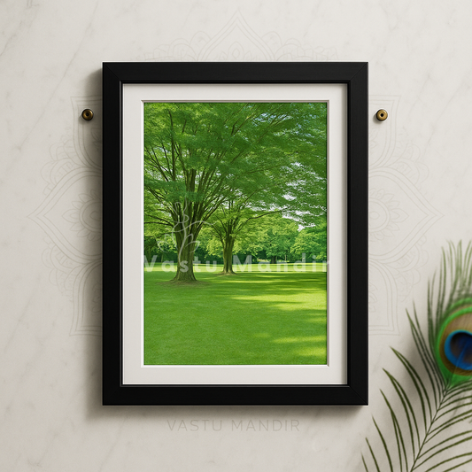 Framed print of a green park scene with trees and grass, mounted on a textured wall.