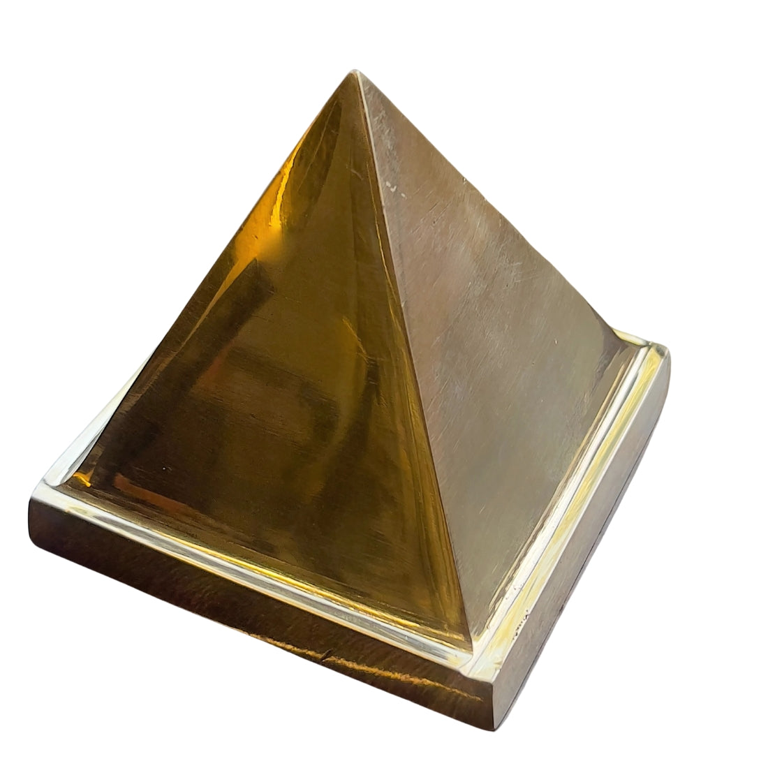 Three-quarter view of polished solid brass pyramid isolated on white background