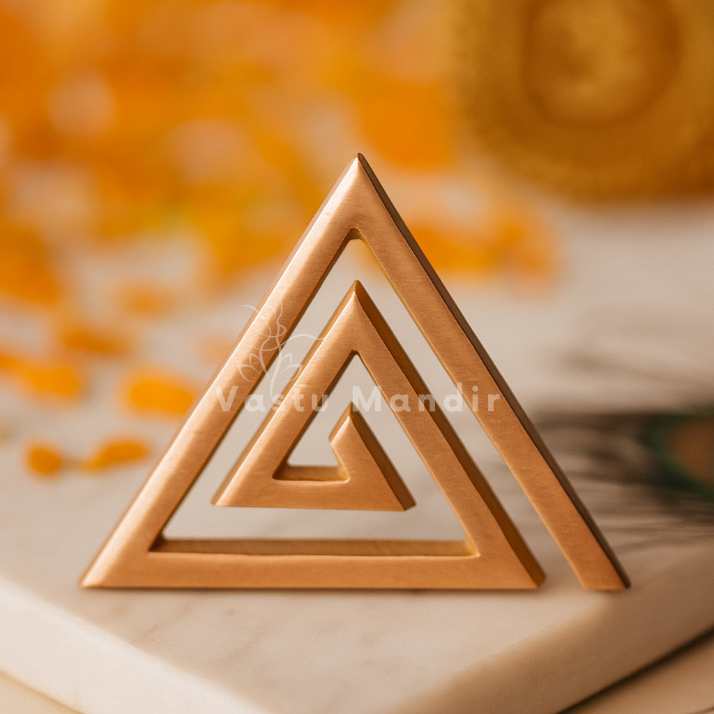 Copper triangle helix standing on stone with marigold petals in the background