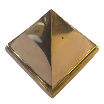 High-angle view of solid brass pyramid isolated on white background