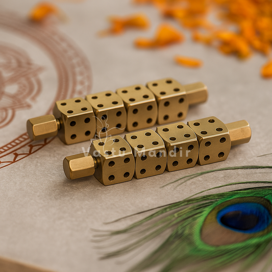 Pair of brass Ramal Pass dice rods displayed with marigold petals and peacock feather