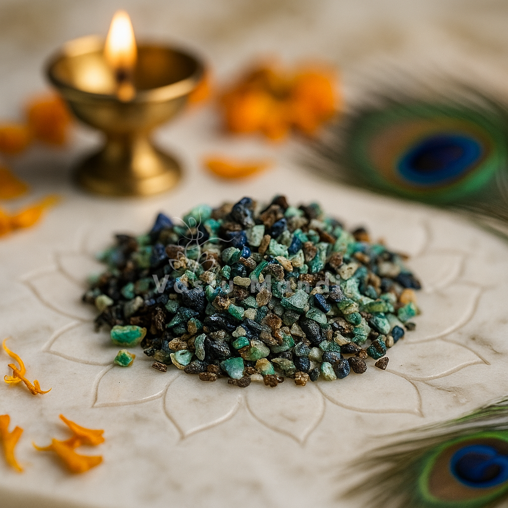 Angled view of azurite crystal chips on a white plate with marigold petals and a peacock feather