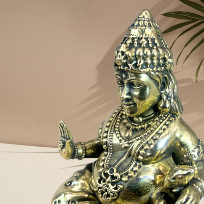 Brass Lord Dhan Kuber Ji idol close-up of the face, crown and raised hand