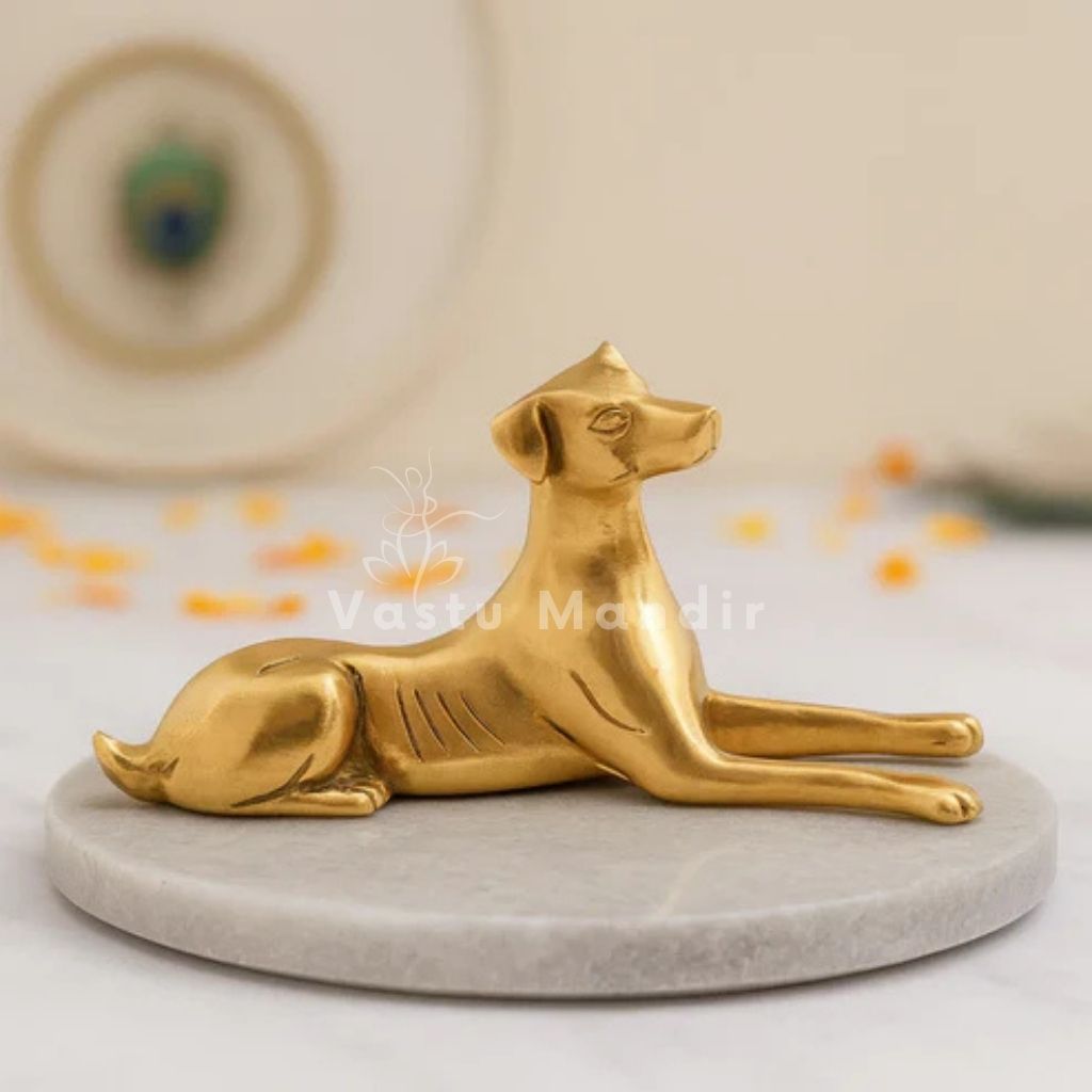 Reclining brass dog idol reclining on a round marble pedestal in a styled interior