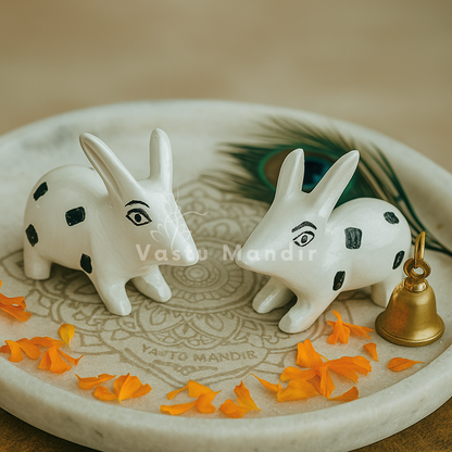 White enamel rabbit pair pair displayed together with bell and marigold petals