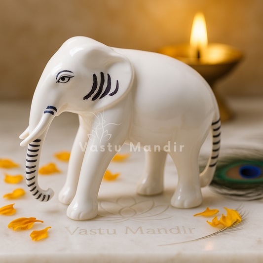 White-finish elephant idol on a sacred white plate with diya and flowers