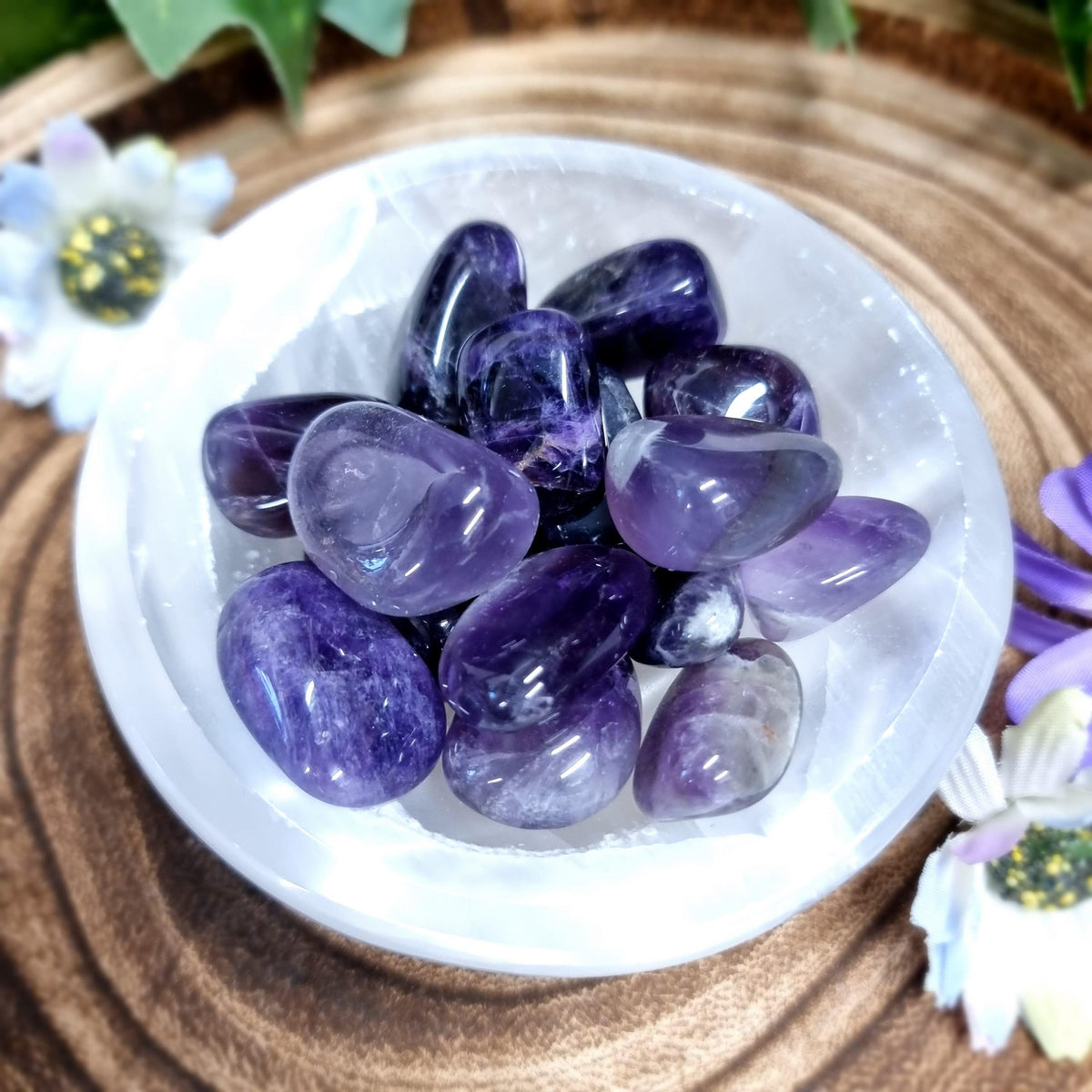Amethyst stones displayed in a small bowl with a neutral background