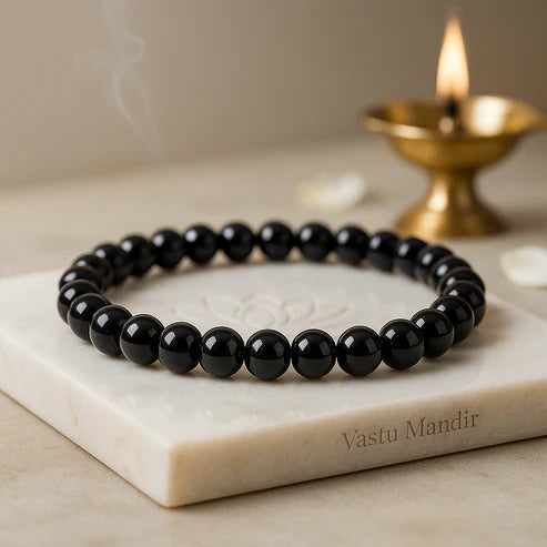 Natural black obsidian crystal bracelet presented with a hand for visual scale