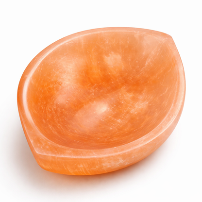 Orange divyya selenite charging bowl displayed in a softly lit product setting