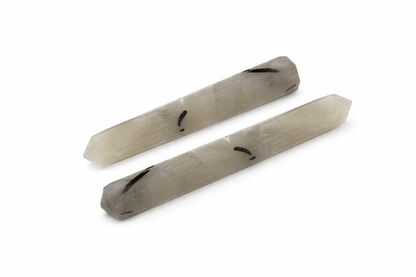Black rutile crystal pencil centred in a white-background product photograph