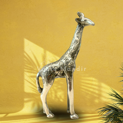 Brass giraffe idol displayed against a golden wall with leaf shadows