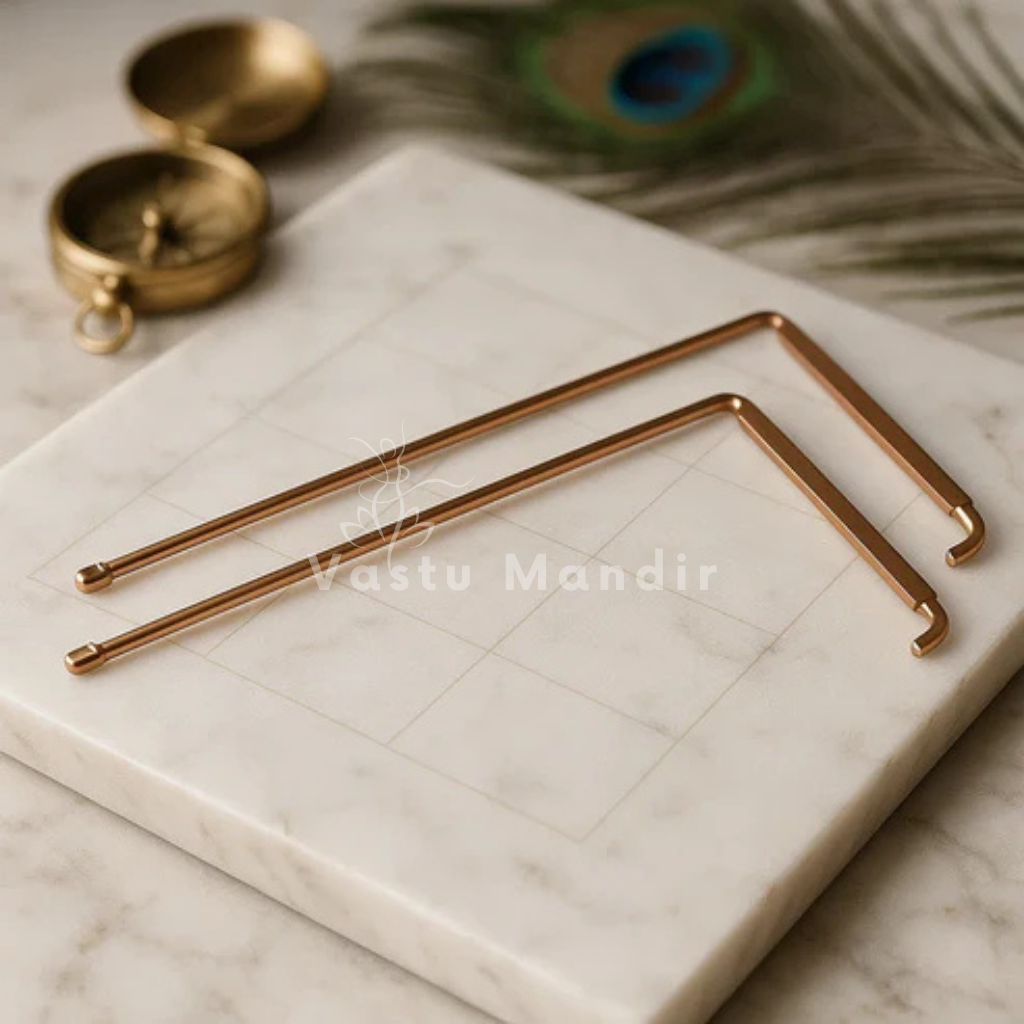 Copper L-shaped dowsing rod pair displayed on a marble board with sacred accents