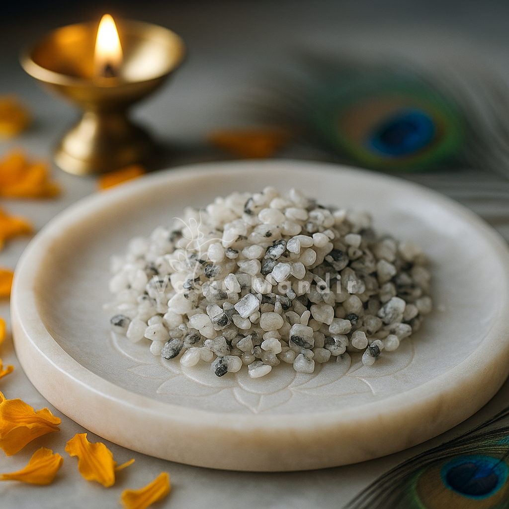 Moonstone crystal chips arranged on a carved white plate with marigold petals and a softly lit diya