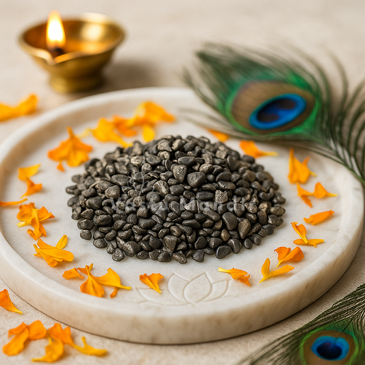 Pyrite crystal chips arranged on a carved white plate with marigold petals and a softly lit diya