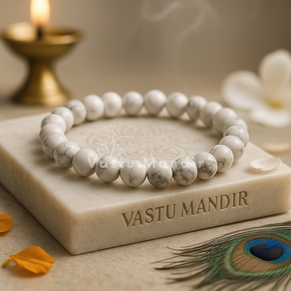 White Howlite - beaded bracelet on a 'Vastu Mandir' block with a candle and peacock feather in the background