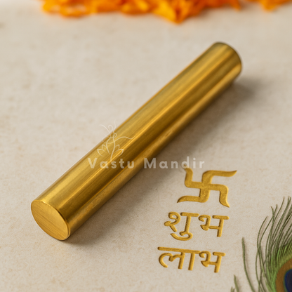 Close-up of polished brass geopathic rod beside an auspicious Hindi inscription