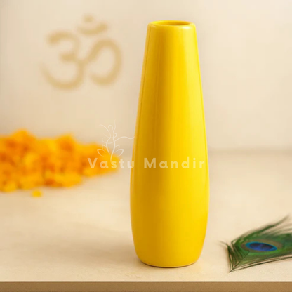 Large yellow resin vase displayed on a marble pedestal with sacred decorative accents