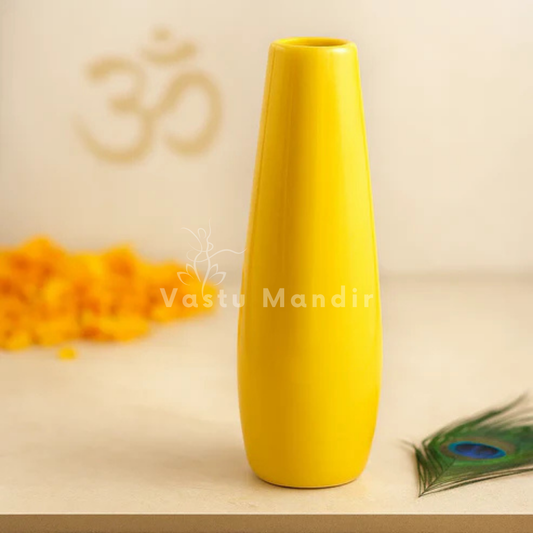 Large yellow resin vase displayed on a marble pedestal with sacred decorative accents