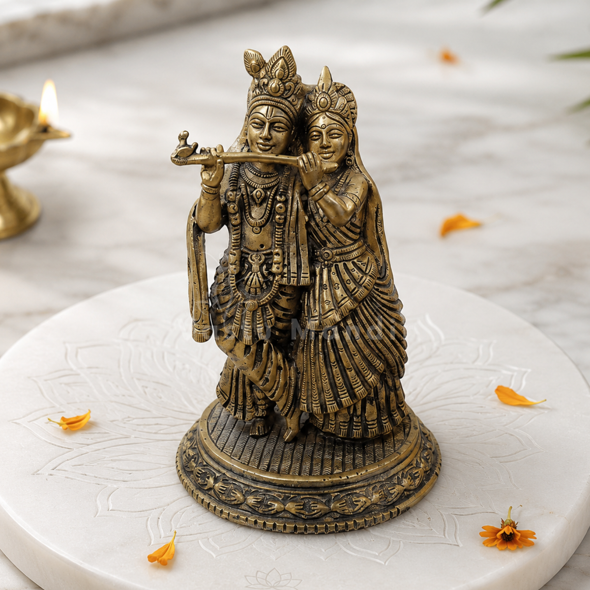 Brass Radha Krishna idol on a sacred marble plate with floral accents