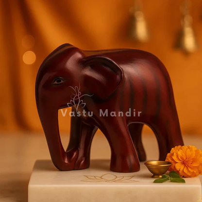 Royal red elephant resin sculpture Vastu remedy displayed in a dark, softly lit spiritual setting