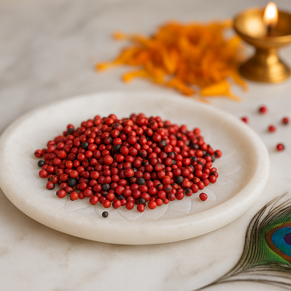 Angled view of red gumchi seeds on a decorated white plate with traditional brass decor