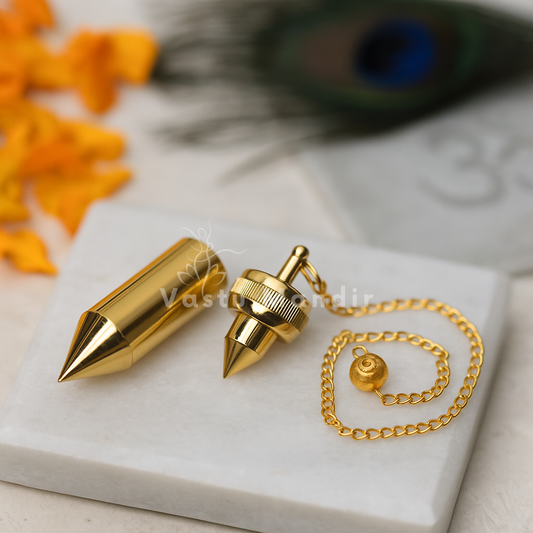 Brass cone dowsing pendulum with chain displayed on a white marble plate
