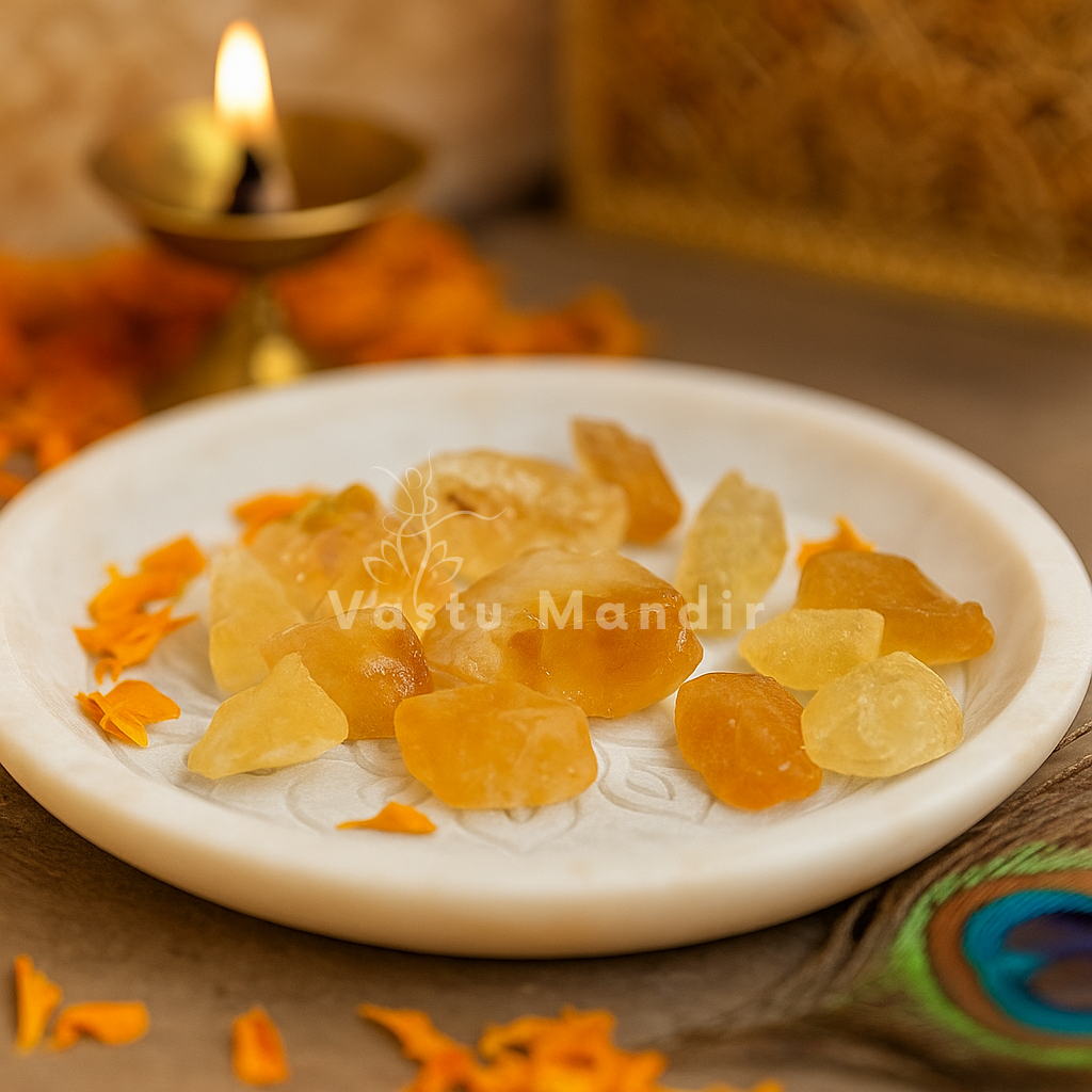 Raw citrine stones arranged on a white plate with marigold petals and a softly lit diya