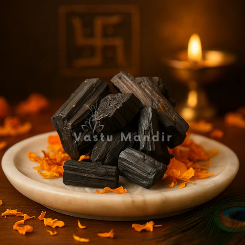 Black tourmaline rods stacked on a white plate in a softly lit traditional setting