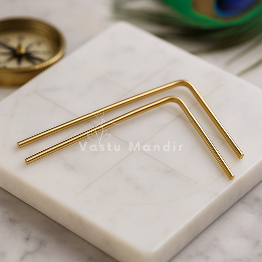 Plain brass dowsing rod pair arranged on a white marble board