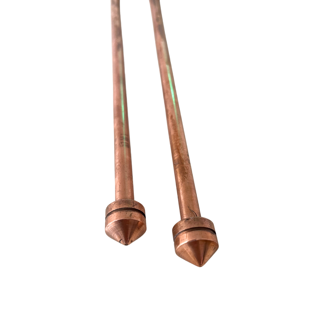 Close-up of pointed copper tips on the metal-handled dowsing rods