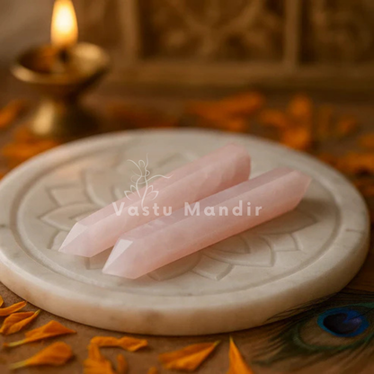 Rose quartz crystal pencil displayed in a dark, softly lit spiritual setting