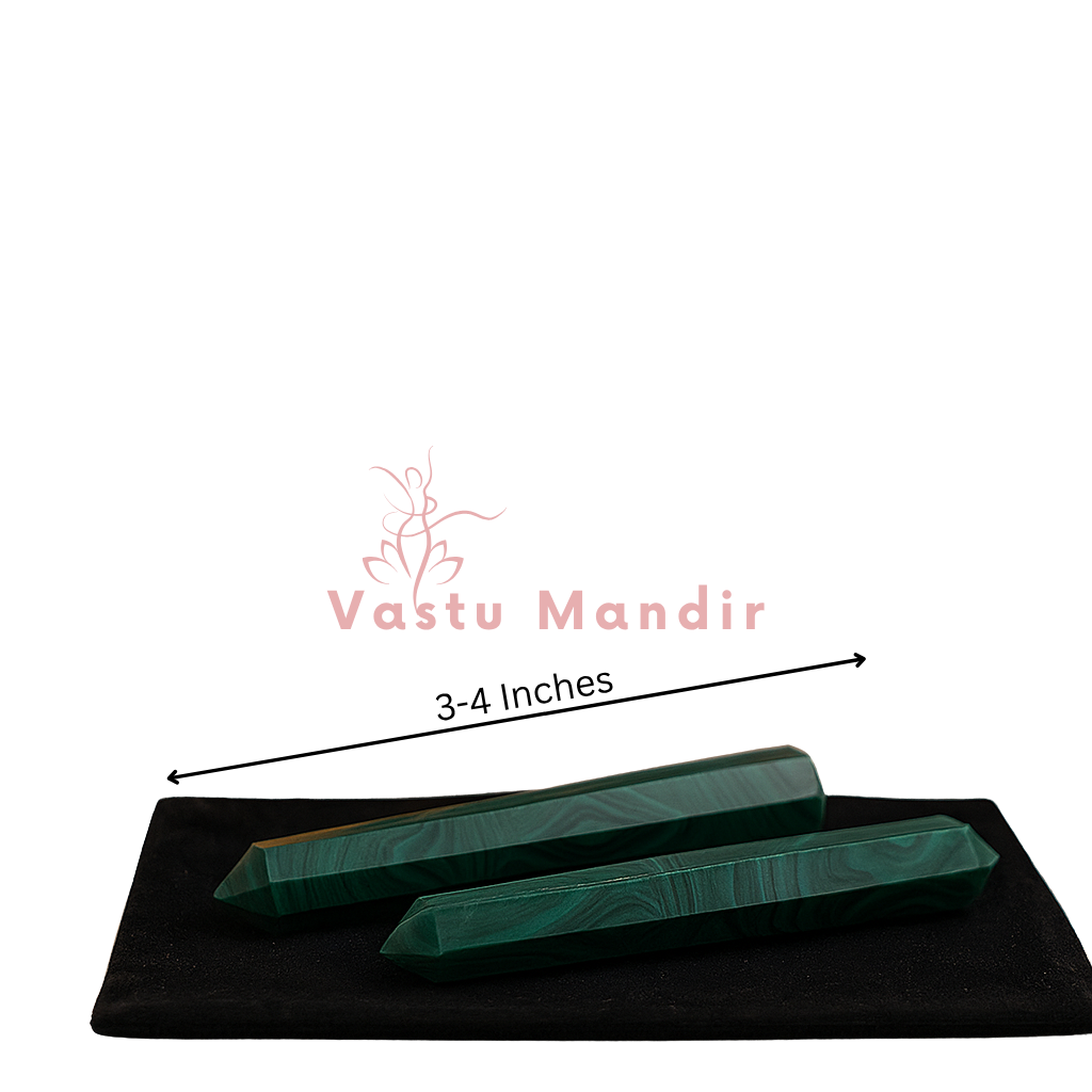 Two malachite crystal pencils presented on a black base against a white background