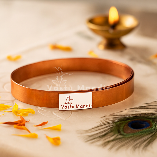 Pure copper Vastu strip coil on a branded plate with diya, petals and peacock feather