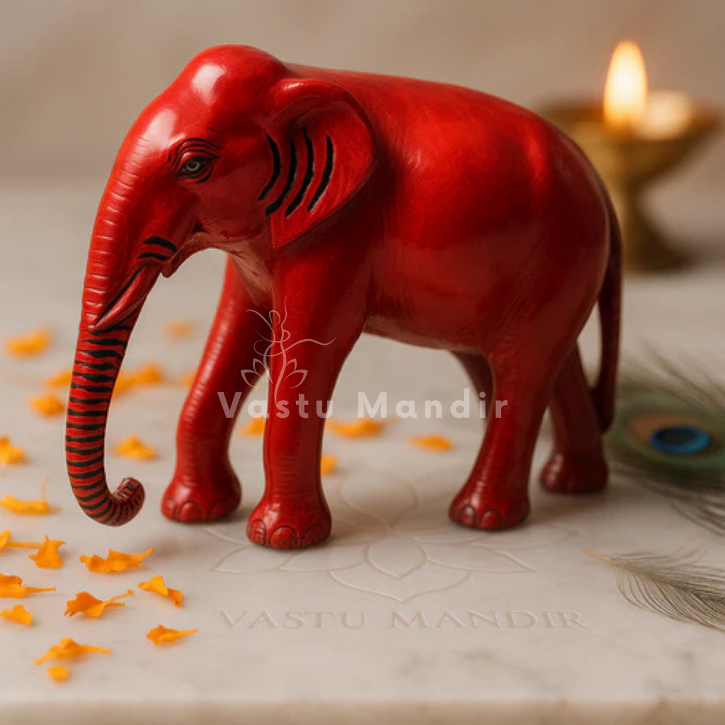 Red-finish elephant idol on a sacred white plate with diya and floral accents
