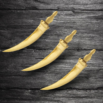 Curved brass talwar miniature three brass talwar miniatures arranged on dark wood