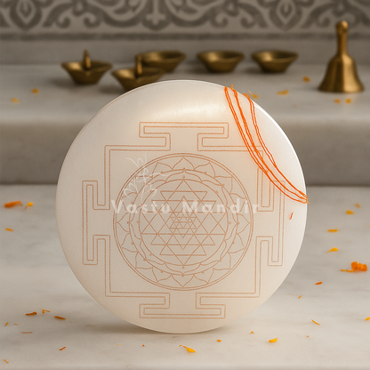 Shree yantra selenite plate shown upright with the engraved design and orange threads