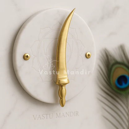 Curved brass talwar miniature on a white marble disc with peacock feather accents