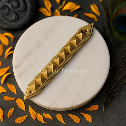 Brass Pyramid Strip on a white plate with orange leaves and 'Vastu Mandir' branding.