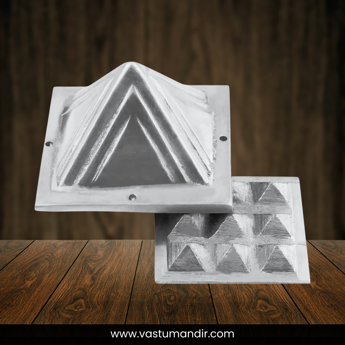 Two lead pyramid layers displayed separately on a dark wooden surface