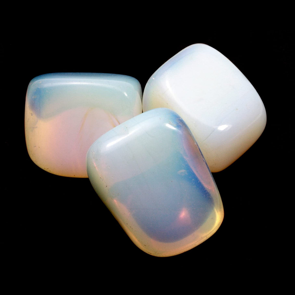 Three square opalite stones displayed against a deep black background