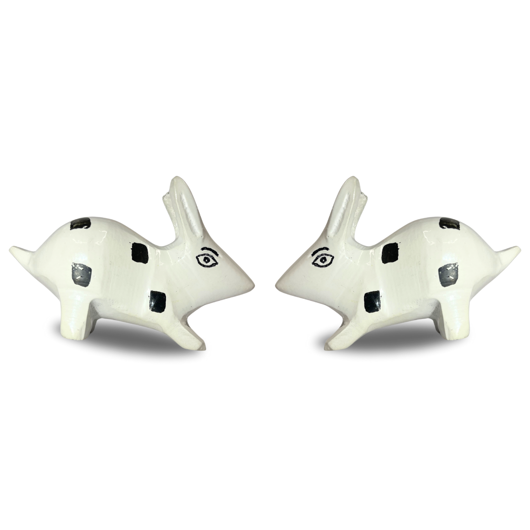 White enamel rabbit pair pair arranged facing away from each other on white background
