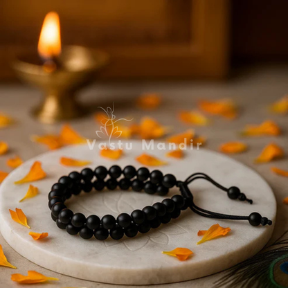 Natural black tourmaline dual strand bracelet presented with a hand for visual scale