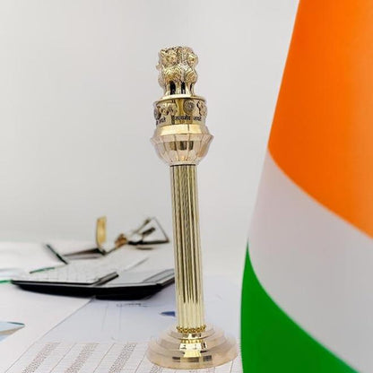 Brass Ashoka Pillar idol displayed beside the Indian flag on an office desk