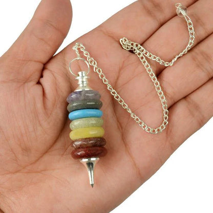 Full seven chakra pendulum and chain held in hand for size reference