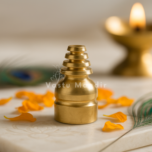 Brass Vastu cone stud displayed upright on marble with marigold petals